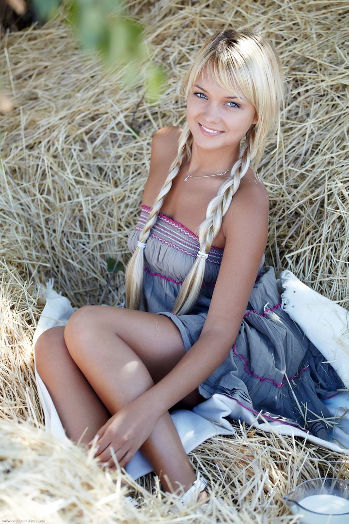 Красивая деревенская девушка с косой в поле